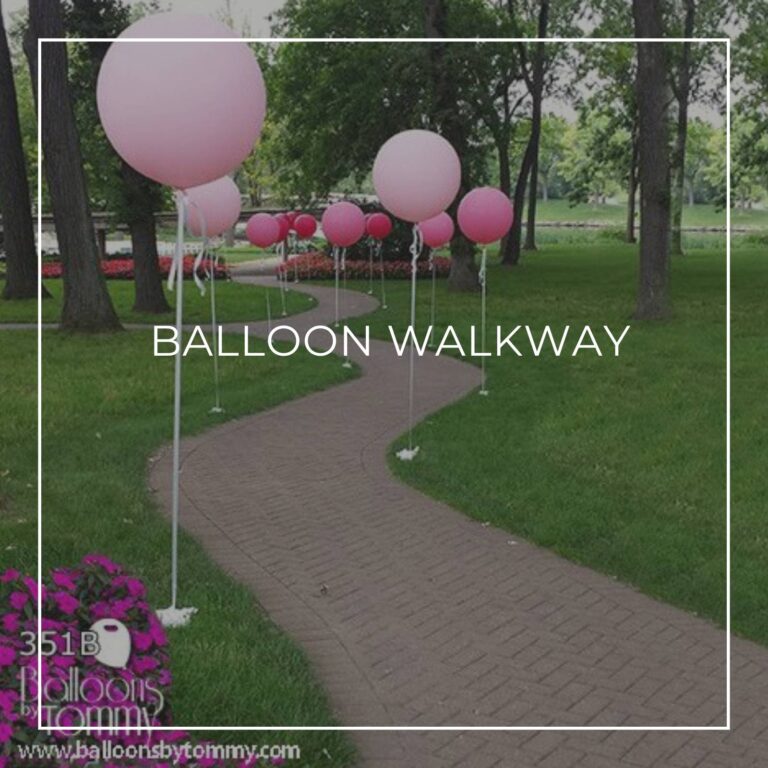 pink helium-filled balloons on strings staked into grass either side of a pathway