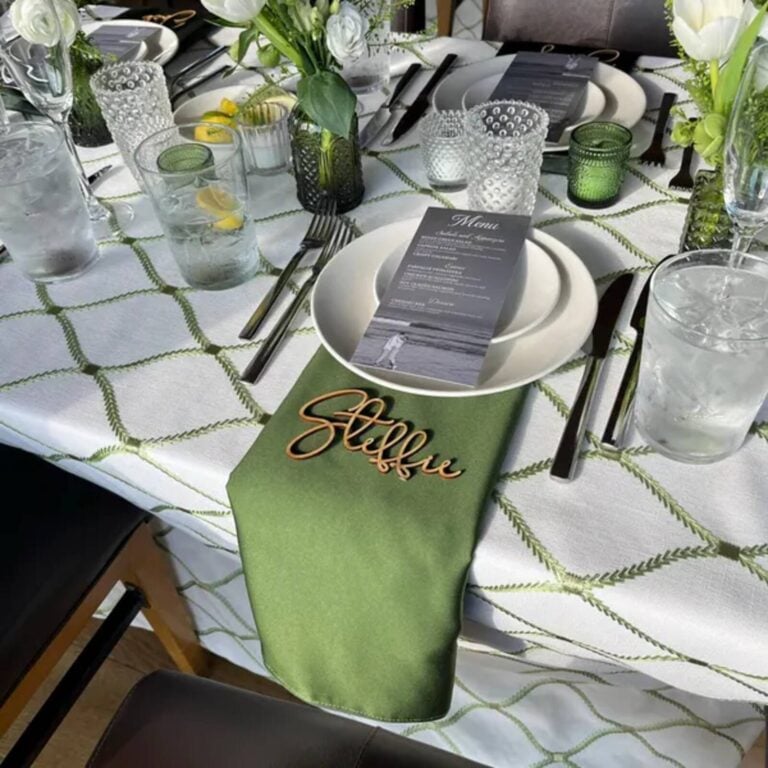 Wooden script name Steffie on a green napkin at a white plate setting with a menu card