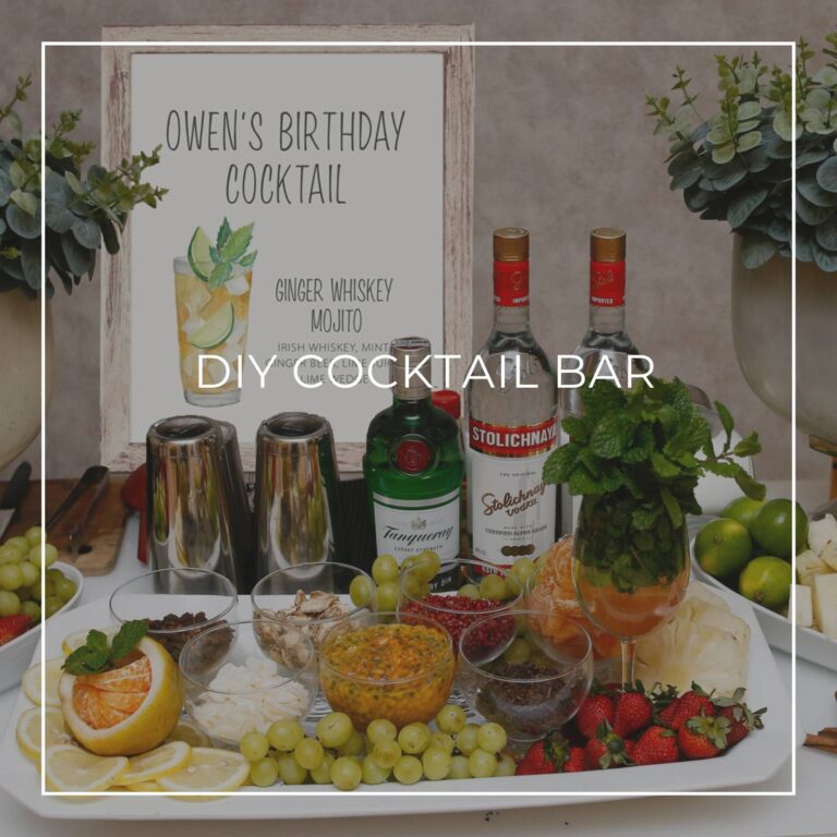 DIY cocktail bar with liquor, ingredients, and a cocktail recipe sign for party guests to make their own drink