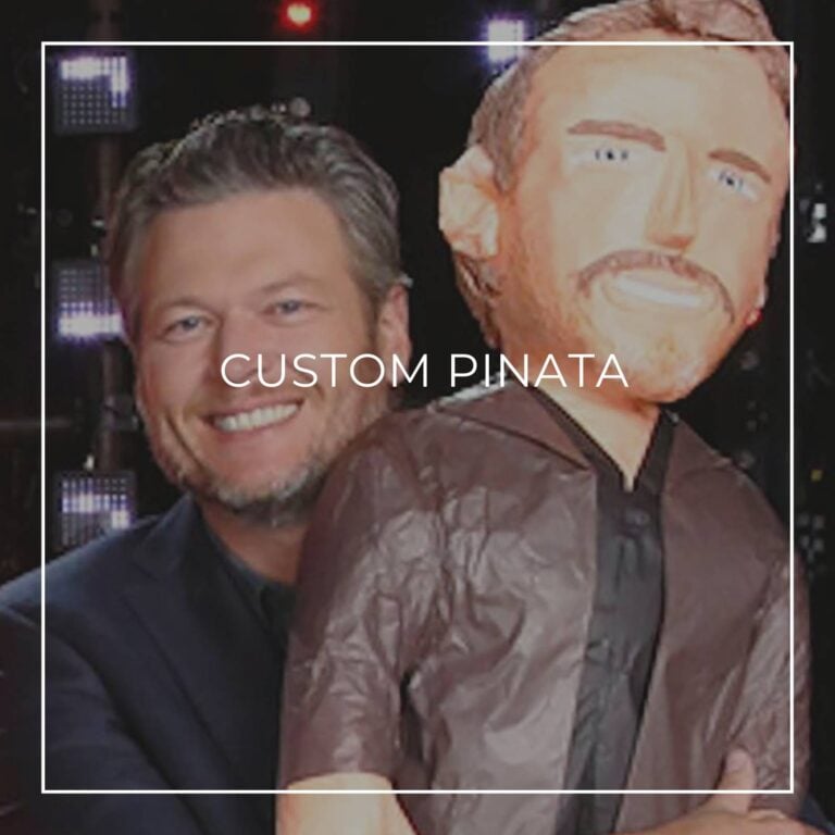 man standing next to a custom pinata of himself