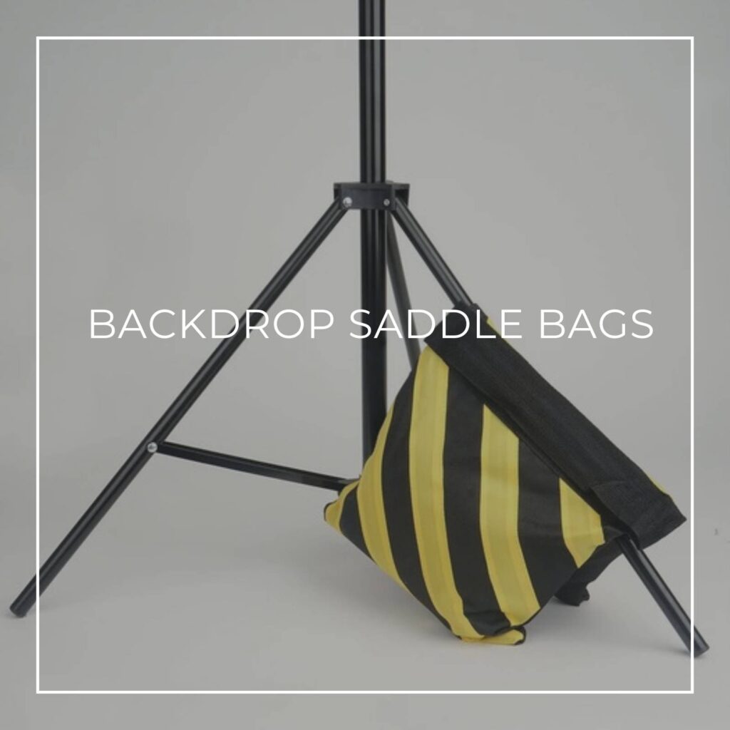 black and yellow striped backdrop saddle bag draped over the base of a backdrop stand for stability