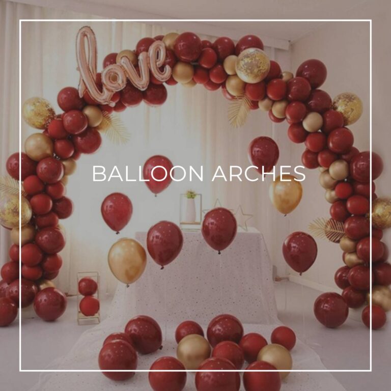 red and gold balloon arch over a party table