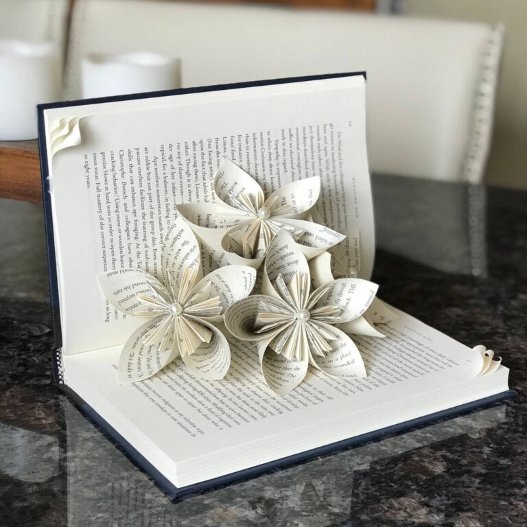 Book art paper flower bouquet with pearl centers blooming from the pages of an open book