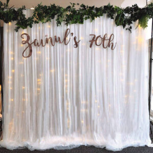 white chiffon tulle fabric party backdrop for a 70th birthday party
