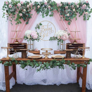 pink and white chiffon tulle fabric party backdrop behind a dessert table for a baby shower party