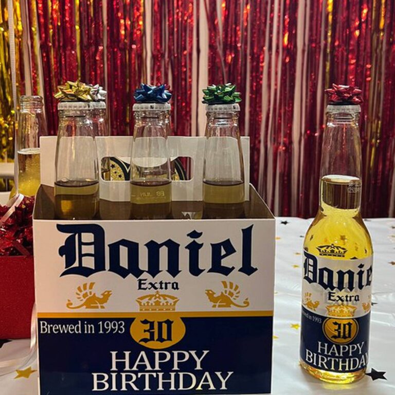 Six-pack with gift bows and a navy and gold "Daniel Extra, Brewed in 1993, 30, Happy Birthday" label against a red foil backdrop