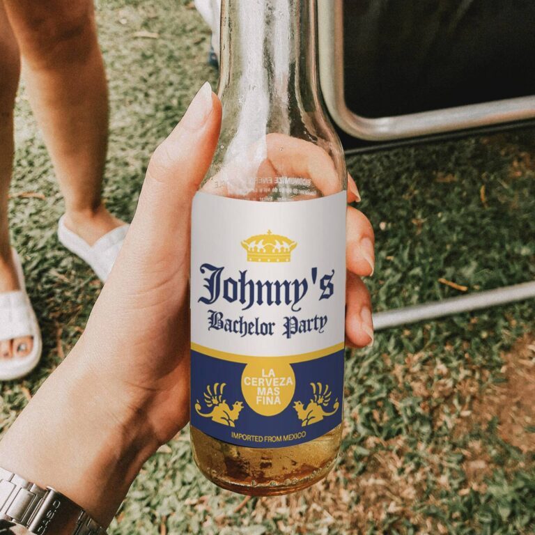 Hand holding a Corona-style bottle outdoors with a custom "Johnny's Bachelor Party, La Cerveza Mas Fina" label