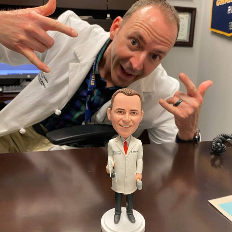 Custom bobblehead of a doctor in a lab coat holding tools, personalized “Dr. Robert” name tag