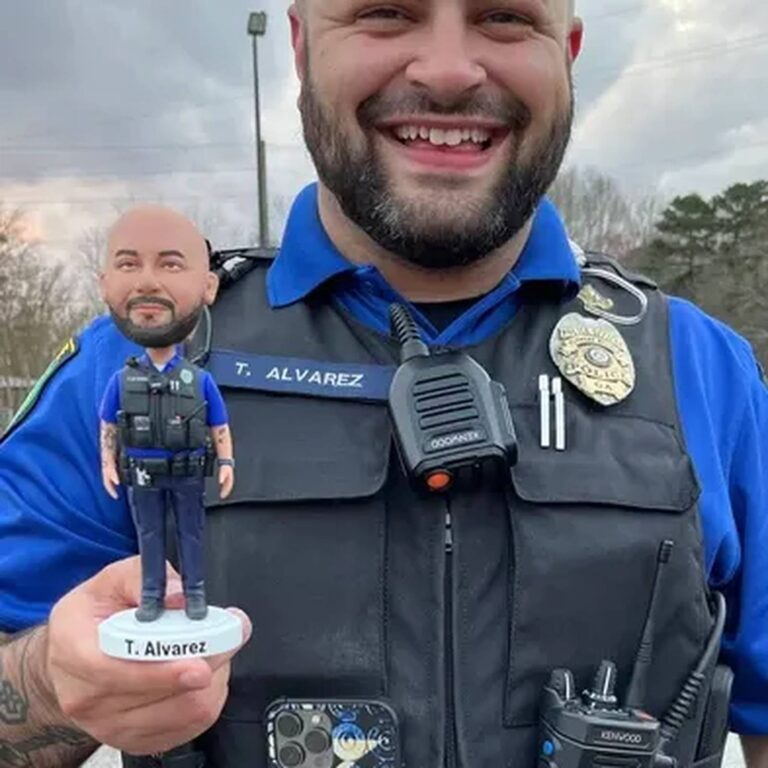 Custom police officer bobblehead labeled “T. Alvarez” in tactical vest, held by the officer