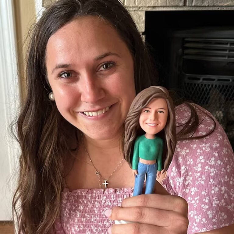 Custom bobblehead of a young woman in a green top and jeans, held next to her smiling