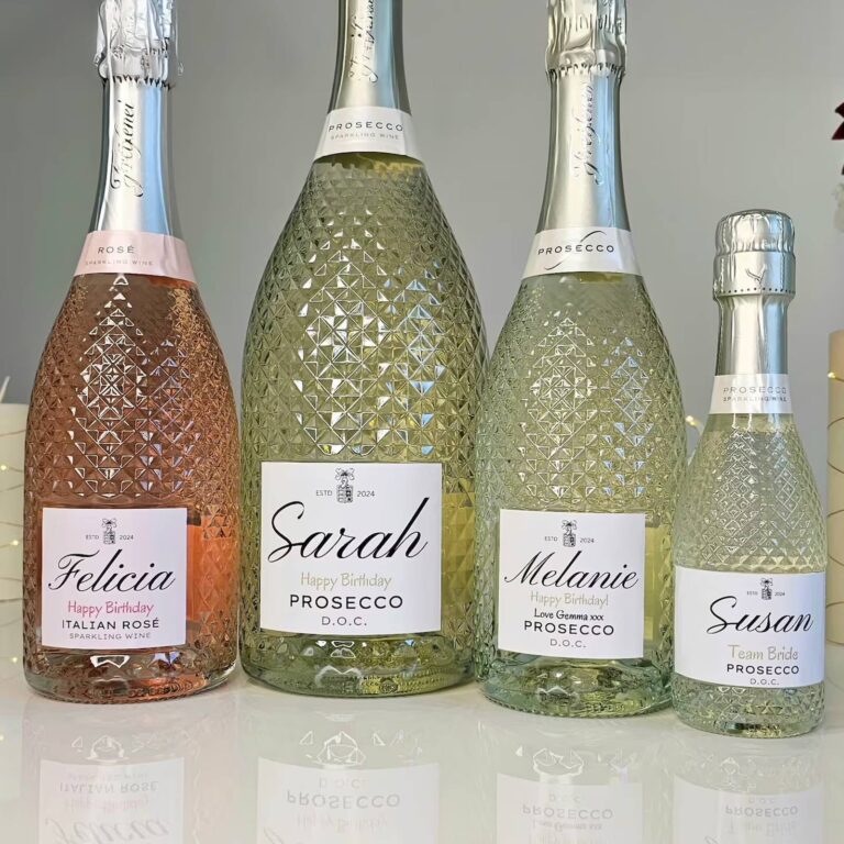 Four textured Prosecco and rosé bottles of different sizes, each with a different guest's name and "Happy Birthday" on the label