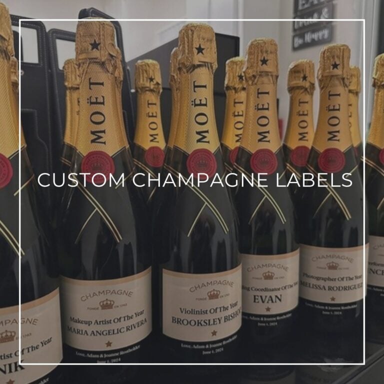 Row of Moët champagne bottles with tan custom "Champagne" award labels naming different wedding vendors like "Makeup Artist of the Year," labeled "Custom Champagne Labels"