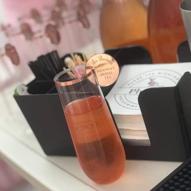 Pink drink in a gold-rimmed glass with a rose gold drink charm reading “La’Quanlia, Brianna’s Bridal Tea”