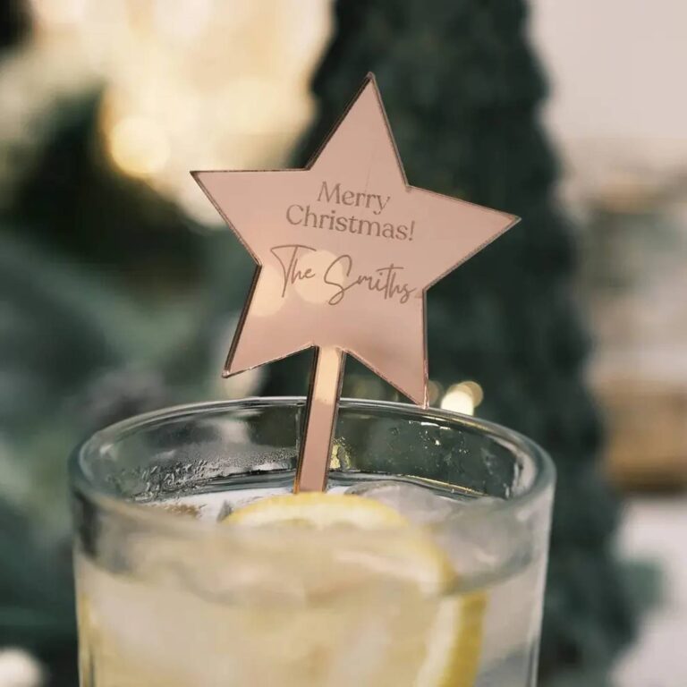 Drink with a rose-gold star-shaped acrylic stirrer reading “Merry Christmas! The Smiths”