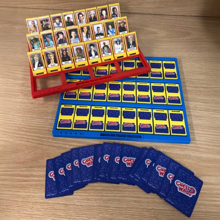 Custom Guess Who red tray full of family name tiles with blank card deck fanned in front