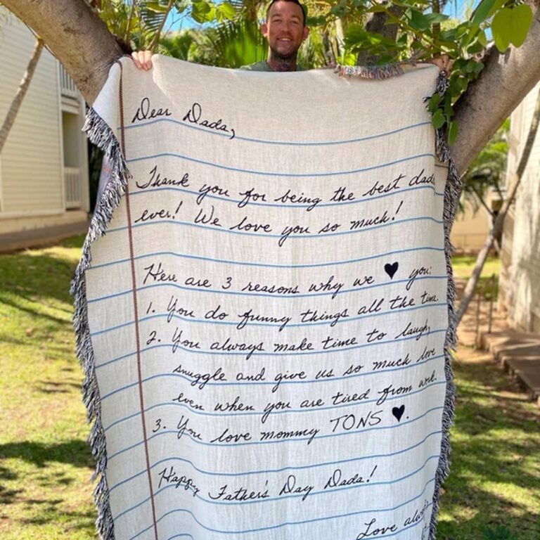 Blanket with ‘Dear Dada’ Father’s Day letter listing 3 reasons, held up outdoors in a tree