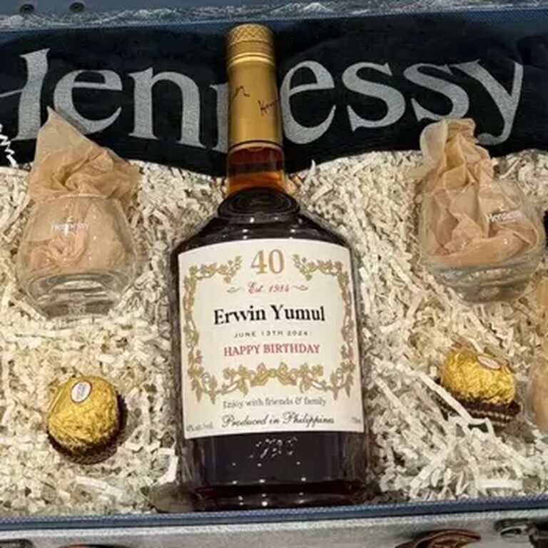 Cognac bottle in a Hennessy gift box with an "Erwin Yumul, 40, Happy Birthday" label, surrounded by glasses and chocolates