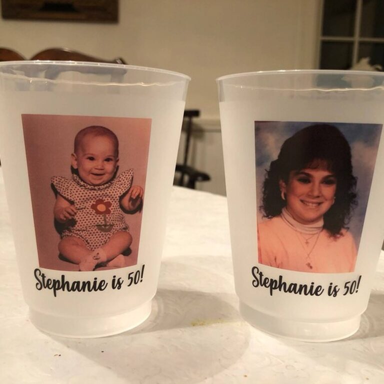 Two frosted photo cups on a table printed with a baby photo and a teen photo, both reading “Stephanie is 50!”