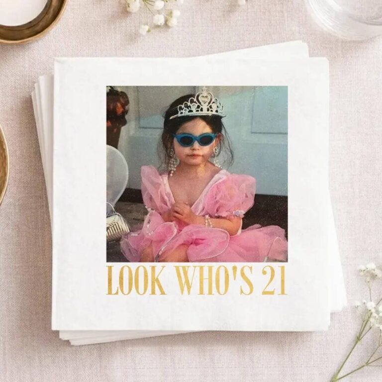 Gold “Look Who’s 21” napkin with a childhood photo of the birthday girl in a tiara and sunglasses