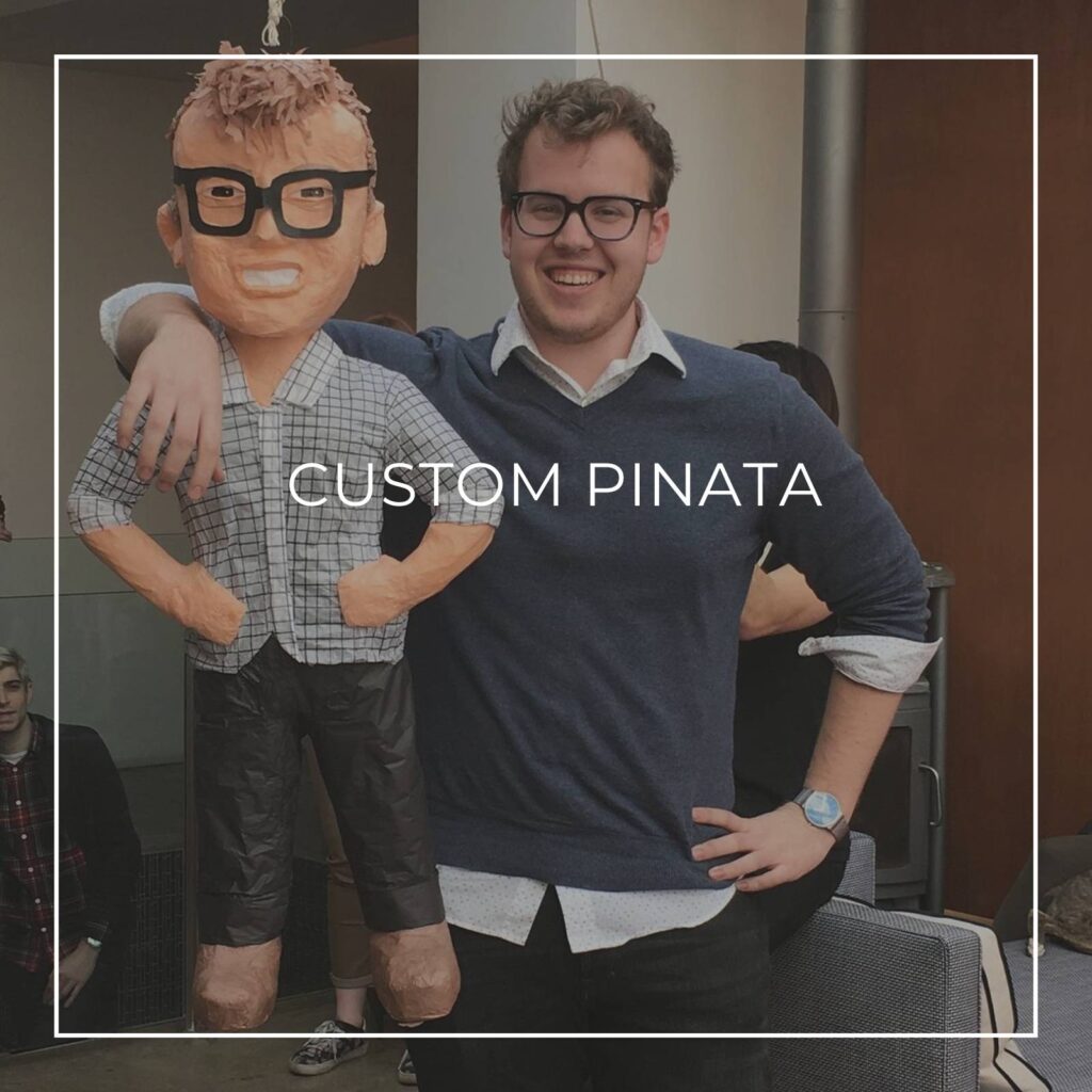 man standing next to a custom pinata of himself