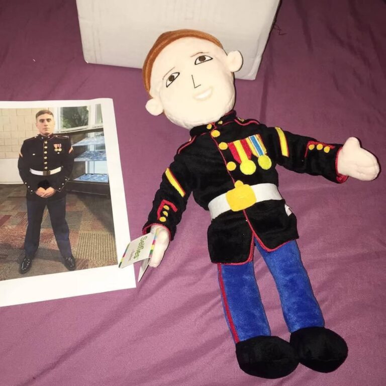 Marine in dress blues next to a custom plush doll wearing the same uniform and medals