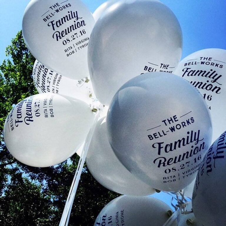 Bunch of custom printed white balloons reading The Bell-Works Family Reunion with date and names