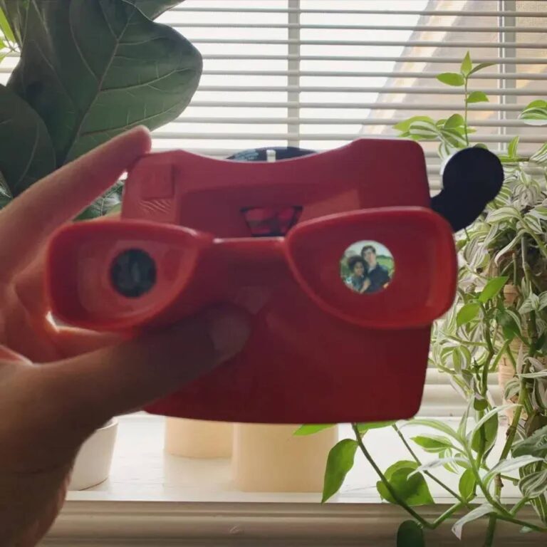 Close-up of a red reel viewer’s eyepieces showing a couple’s photo loaded inside