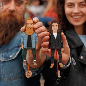 Two custom flat wooden ornaments shaped like a man and a woman, each with a photo charm attached