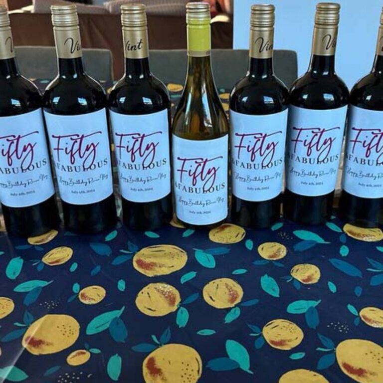 Row of wine bottles labeled “Fifty & Fabulous” for a 50th birthday, dated July 4th