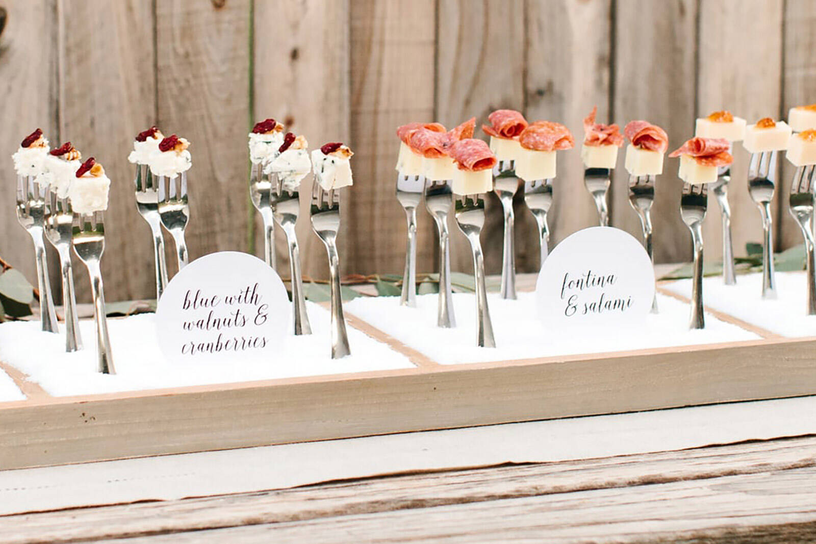cheese bites served on forks standing vertically to add height to your dessert table layout