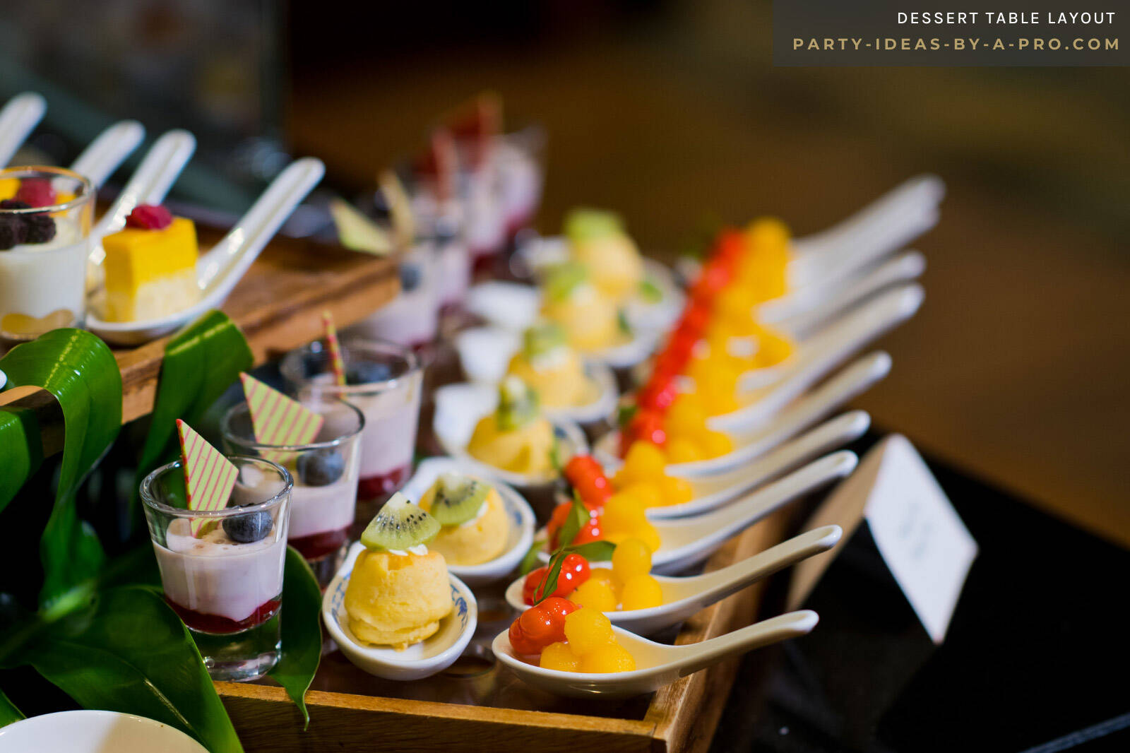 desserts served in tasting spoons laid out in rows on a party dessert table