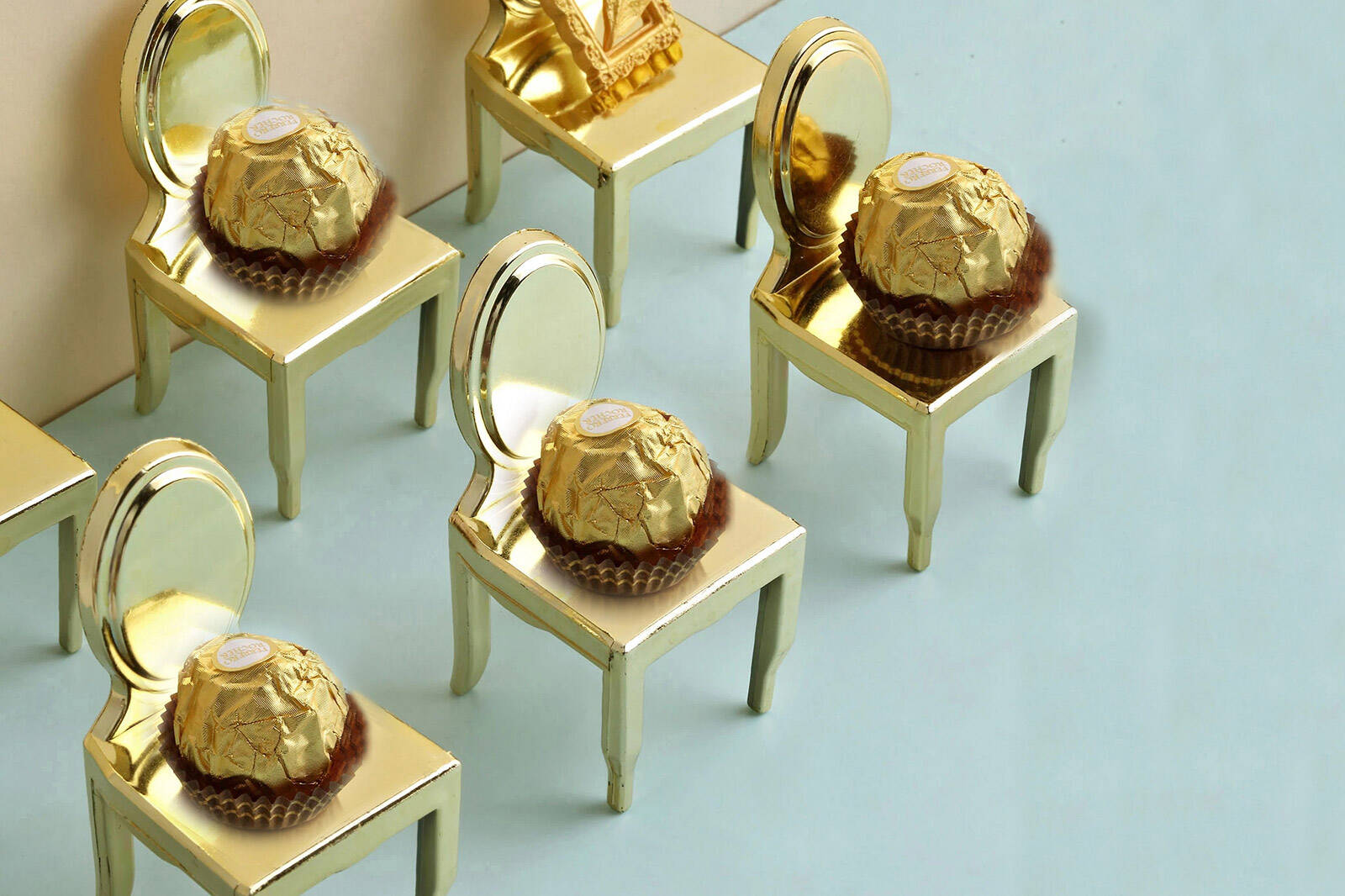 bite size chocolates laid out in rows on mini gold chair treat containers