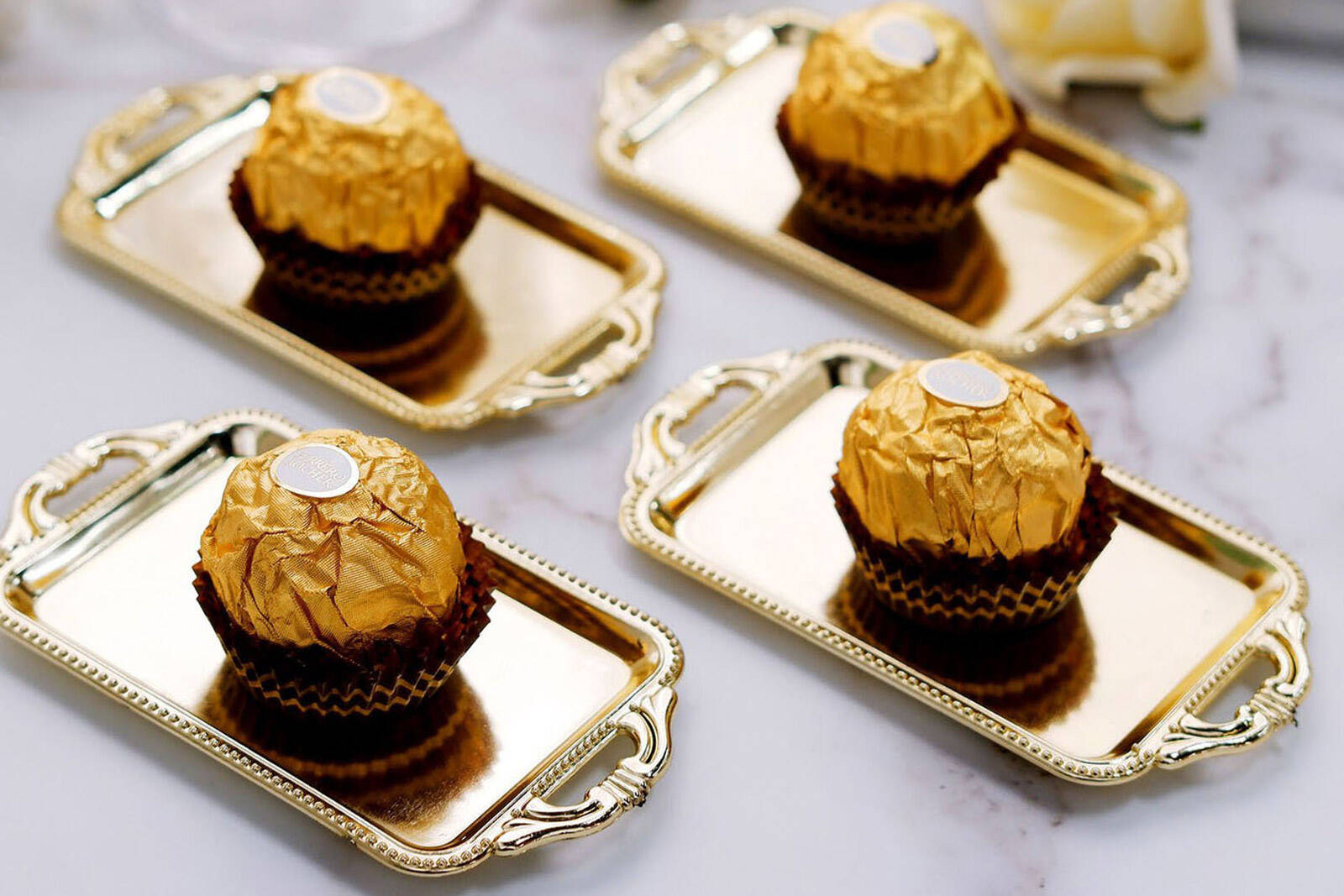 bite size chocolates laid out in rows on mini gold tray treat containers