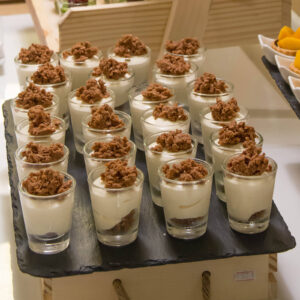 desserts served in shooter glasses laid out in rows on a party dessert table