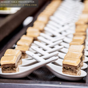 desserts served in tasting spoons laid out in rows on a party dessert table