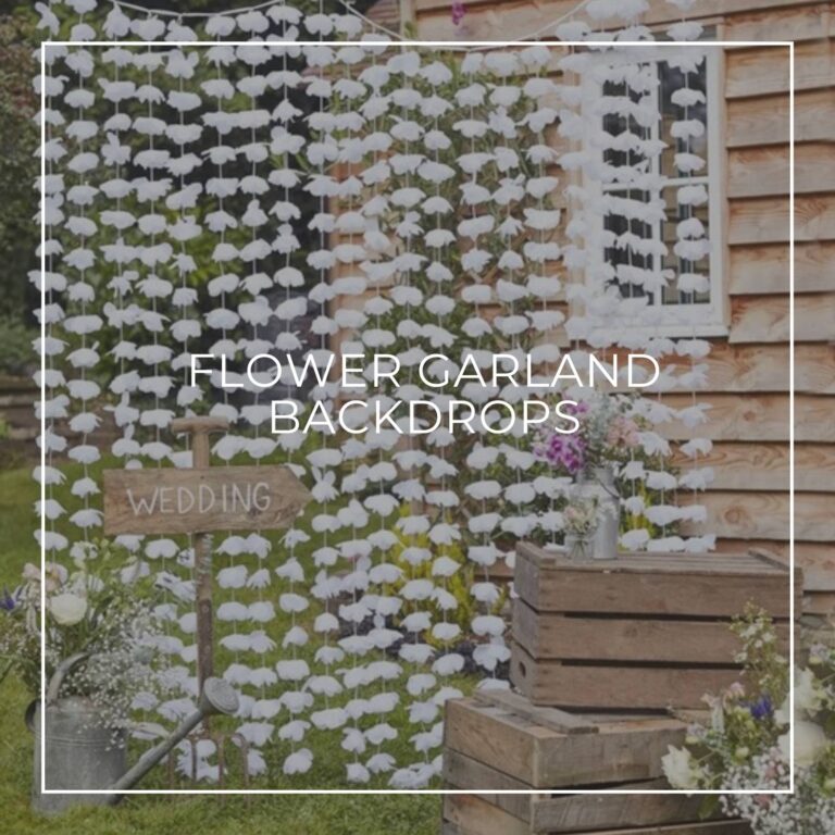 white paper flower garland wedding backdrop in a garden