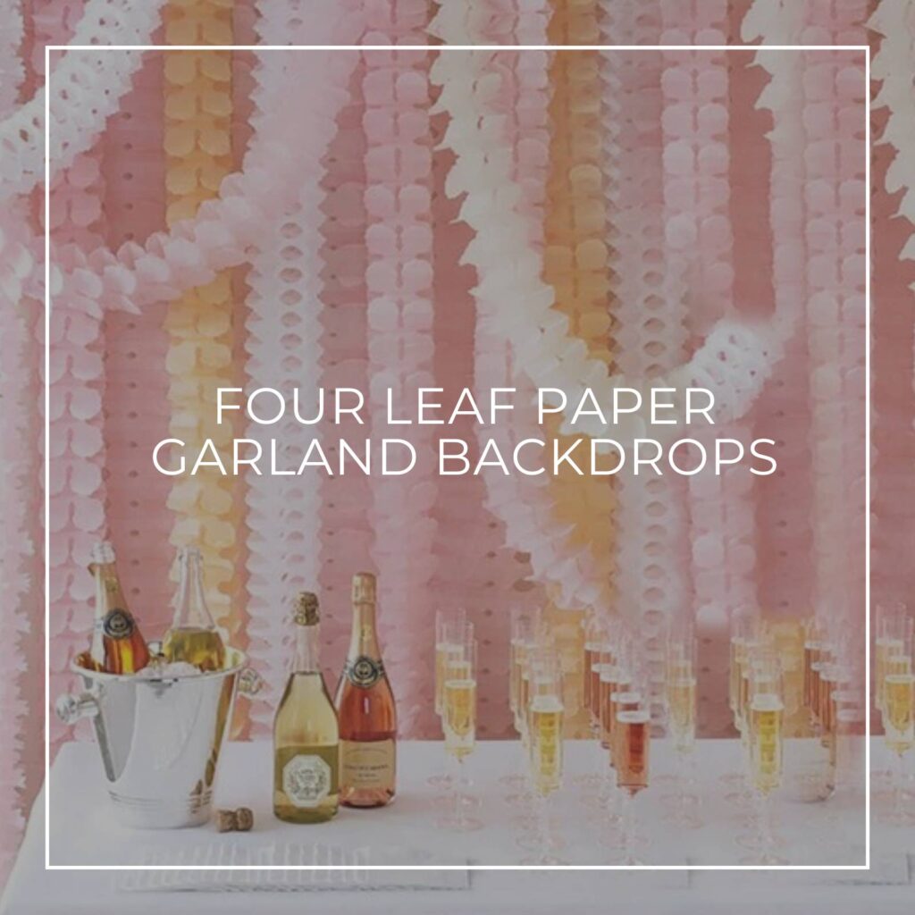 four leaf tissue paper garlands hung vertically to create a bar table party backdrop