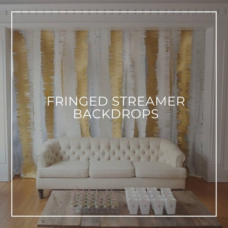 gold and white fringed streamers hung vertically to make a backdrop with a sofa in front