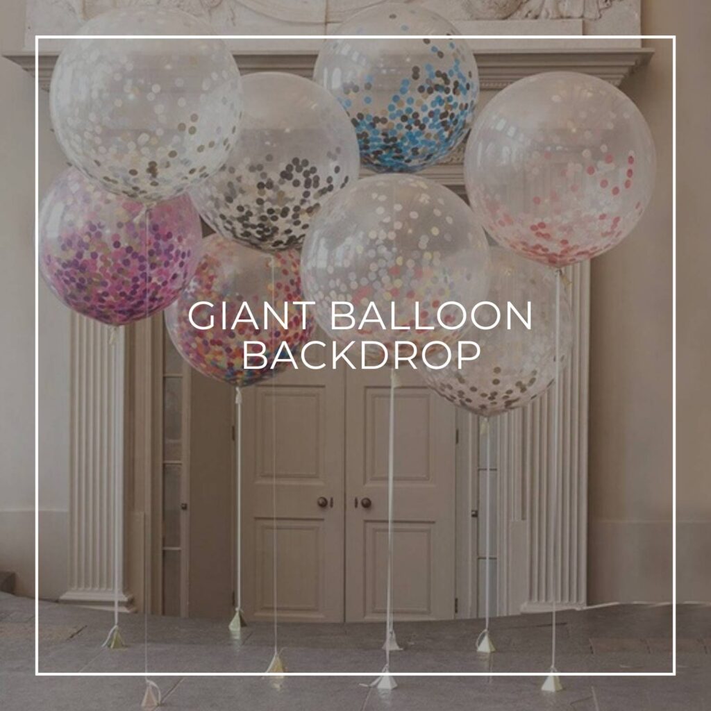 giant transparent glitter filled helium balloons tied to balloon poles and arranged in a cluster