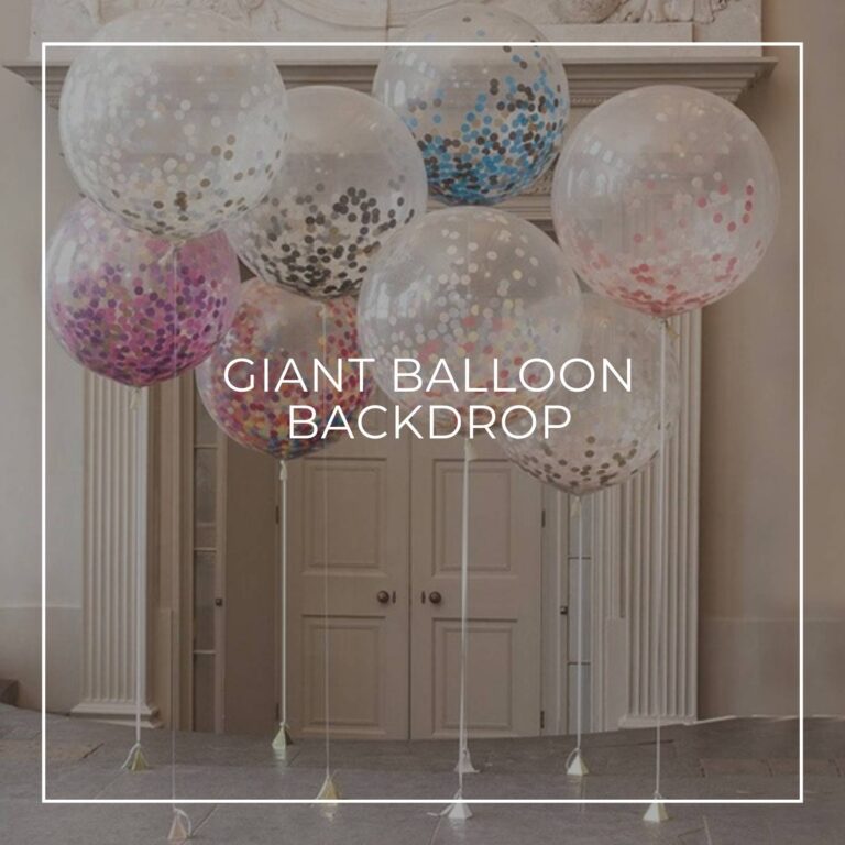 giant transparent glitter filled helium balloons tied to balloon poles and arranged in a cluster as a dessert table / party backdrop idea