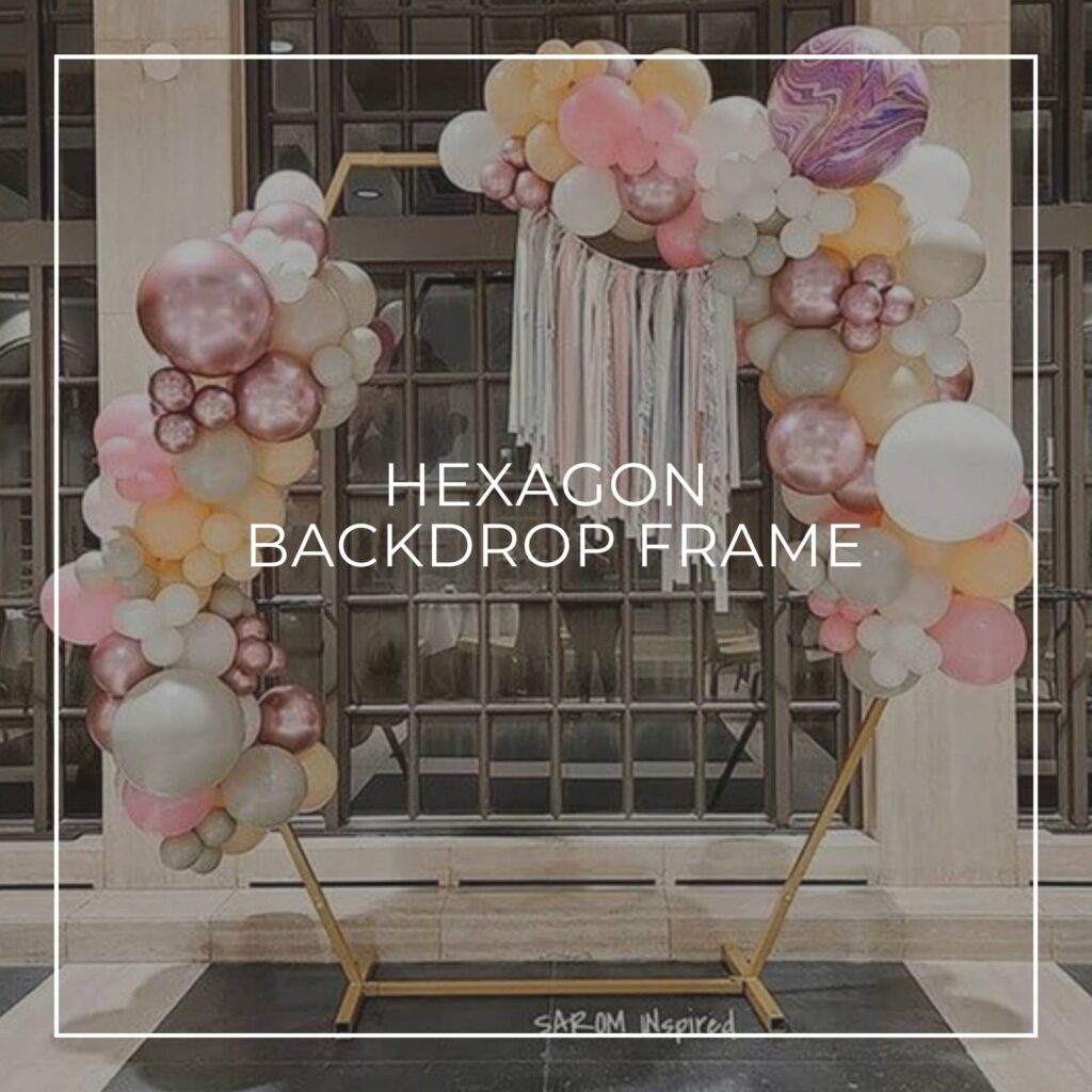 metal hexagon backdrop frame dressed with flowers and an Oh Baby sign