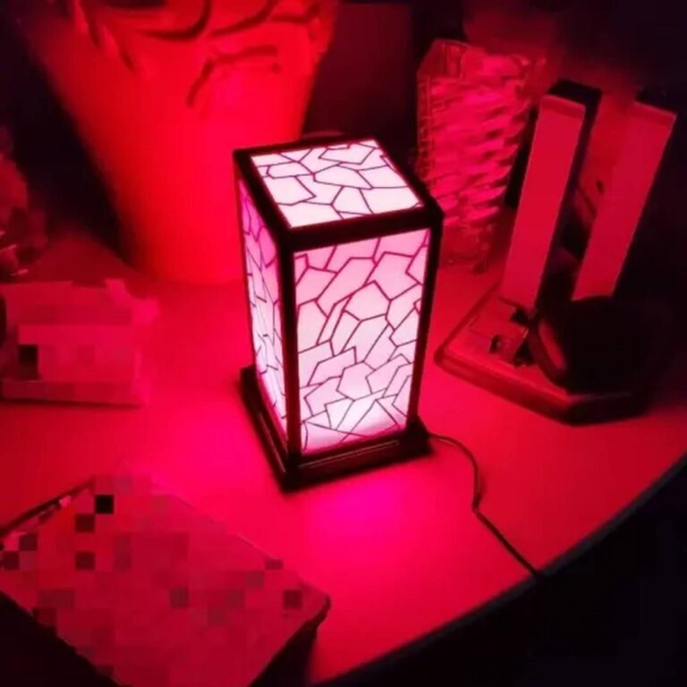 Pink-lit mosaic touch lamp glowing on a table in a dim room