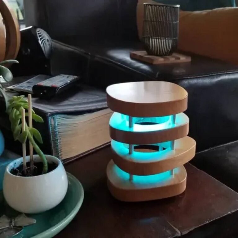 Wood-layered friendship lamp glowing teal on a living room side table