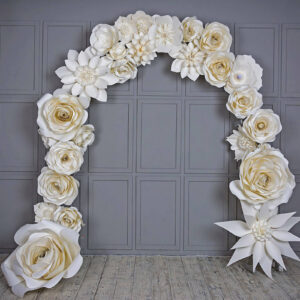 white paper flower decorations hanging on a grey wall