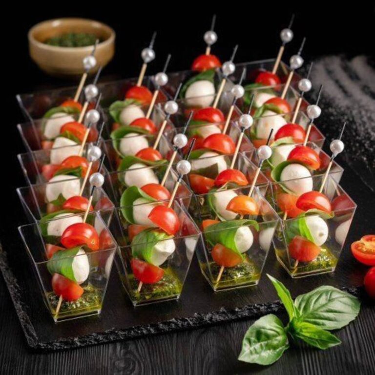 Caprese skewer appetizer cups with mozzarella, cherry tomato, and basil on a pearl-topped pick