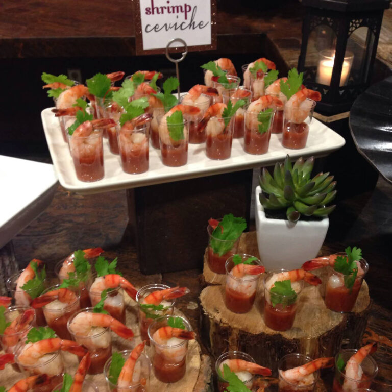 Shrimp ceviche shooters with cilantro garnish arranged on a serving tray