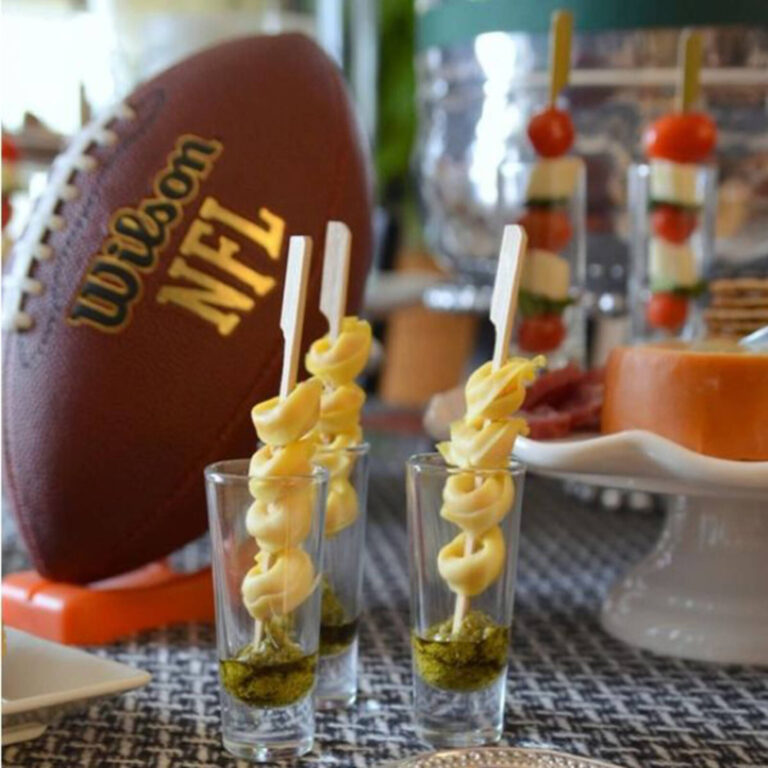 Tortellini skewers over pesto in shot glasses at a football-themed party