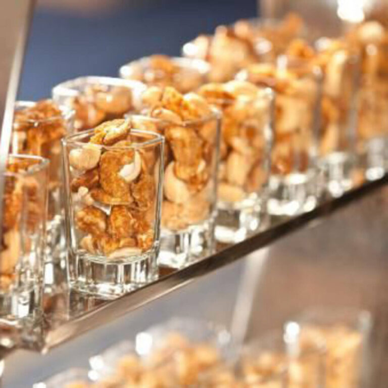 Candied mixed nuts served in square shot glasses in a row