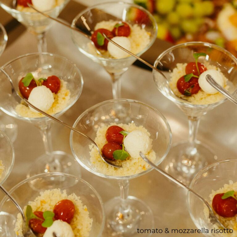 Tomato and mozzarella salad in stemmed glasses with a toasted breadcrumb topping and microgreens