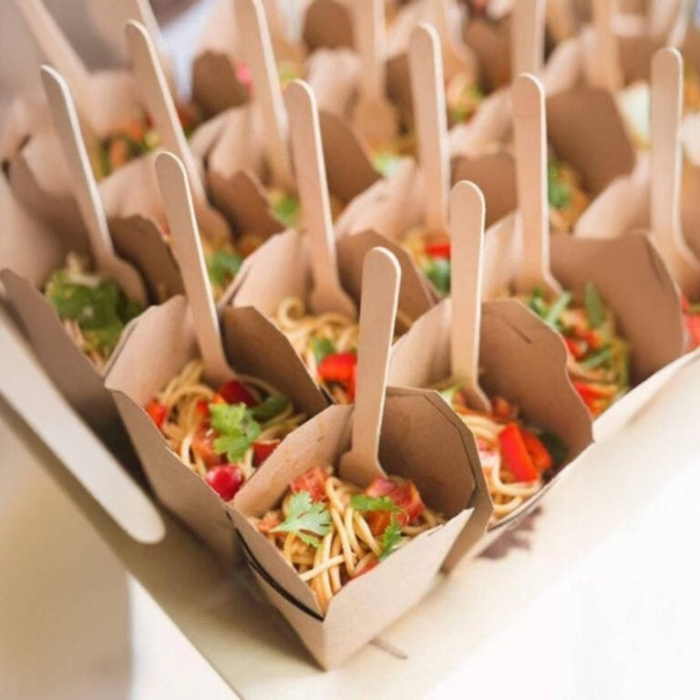 Kraft brown takeout boxes filled with noodle salad and wooden fork picks
